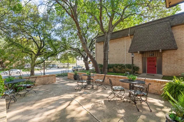 a view of a patio with table and chairs and potted plants with large tree