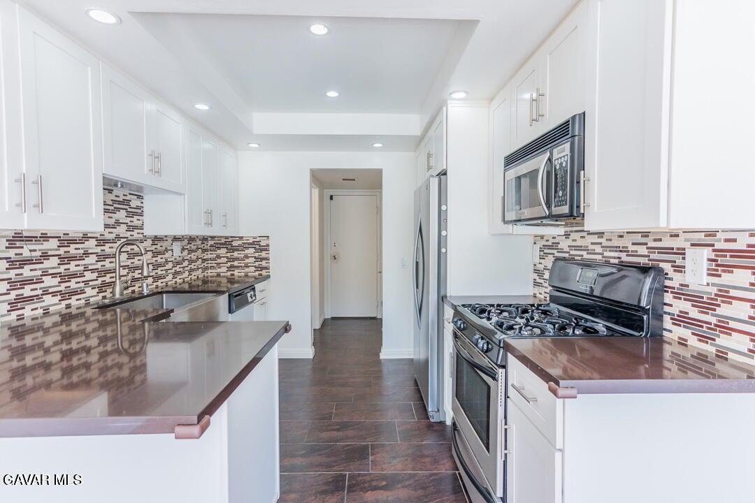 18452 Lemarsh Street, Unit 48 Northridge, CA 91325 - Photo 12 of 45 a kitchen with stainless steel appliances granite countertop a stove and a refrigerator