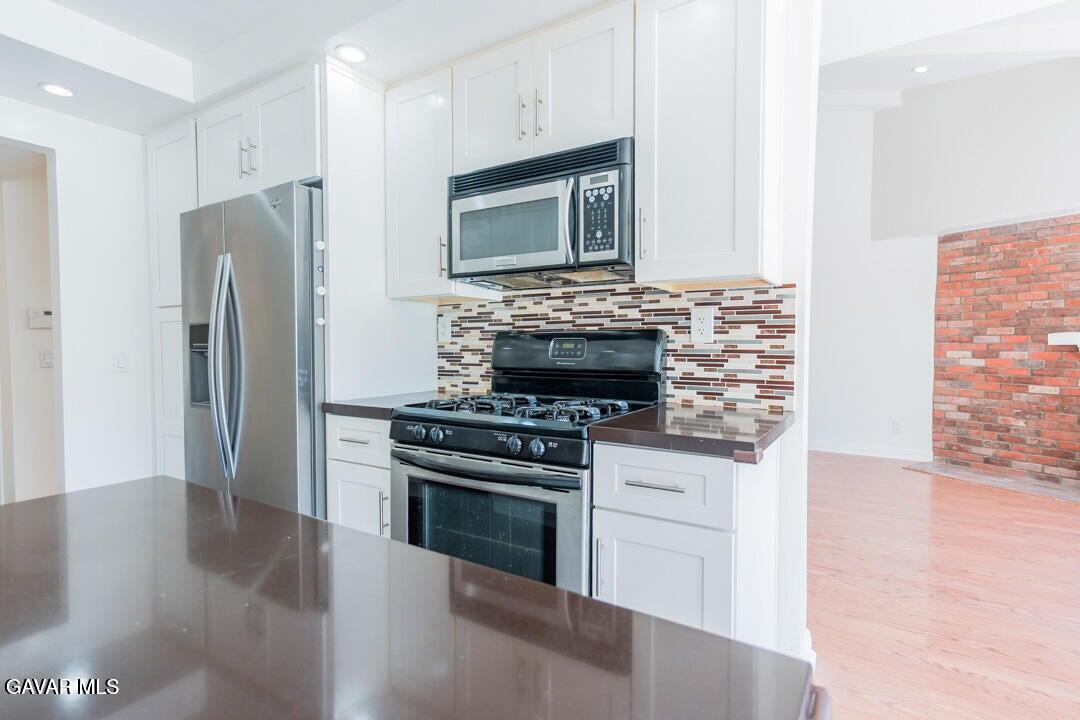 18452 Lemarsh Street, Unit 48 Northridge, CA 91325 - Photo 16 of 45 a kitchen with stainless steel appliances a stove a microwave and a refrigerator