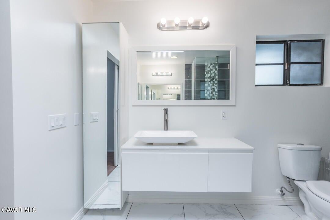18452 Lemarsh Street, Unit 48 Northridge, CA 91325 - Photo 32 of 45 a bathroom with a sink toilet and mirror