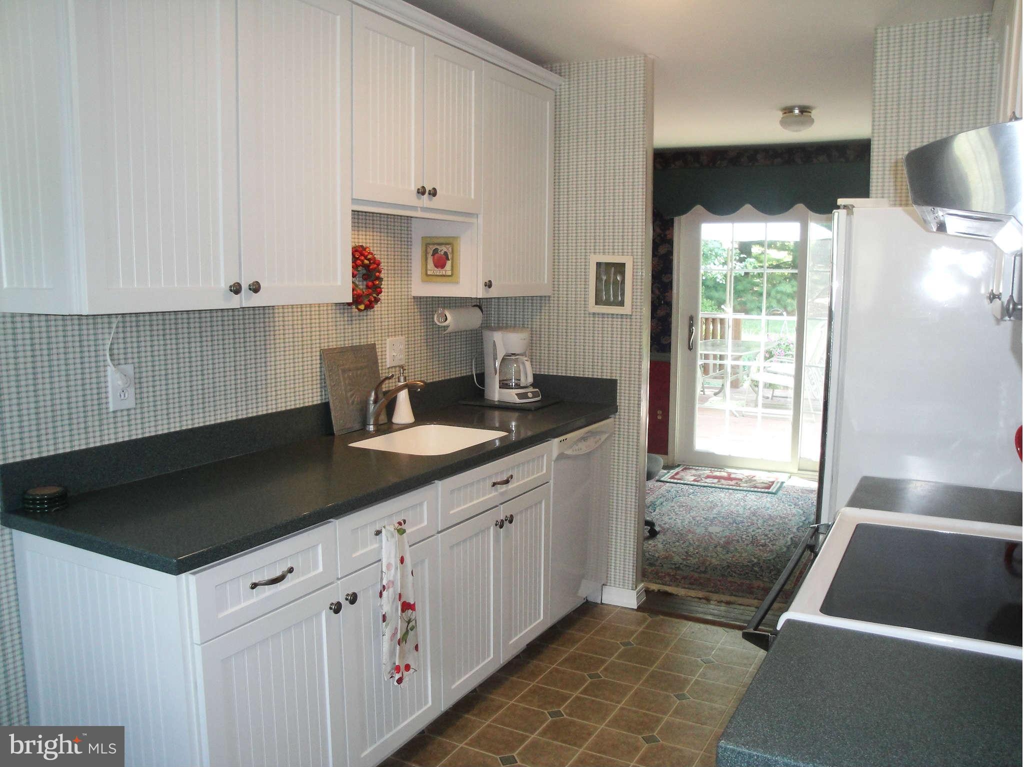 6406 Darwin Road Laurel, MD 20707 - Photo 2 of 22 a kitchen with granite countertop a sink stainless steel appliances white cabinets and a window