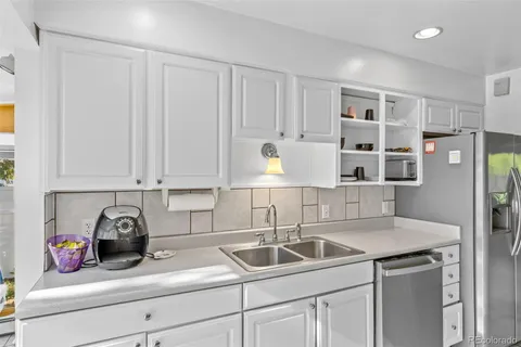 a kitchen with stainless steel appliances granite countertop a sink and a white cabinets