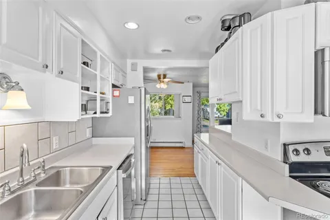 a kitchen with stainless steel appliances granite countertop a sink a stove and a refrigerator