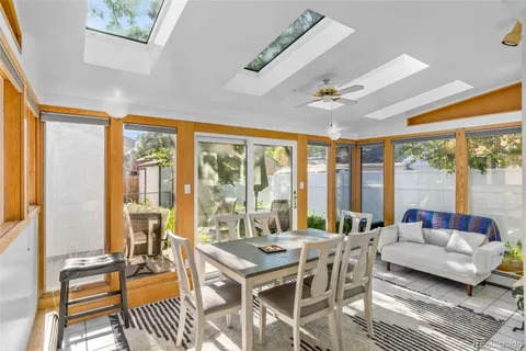 a living room with furniture a ceiling fan and a large window