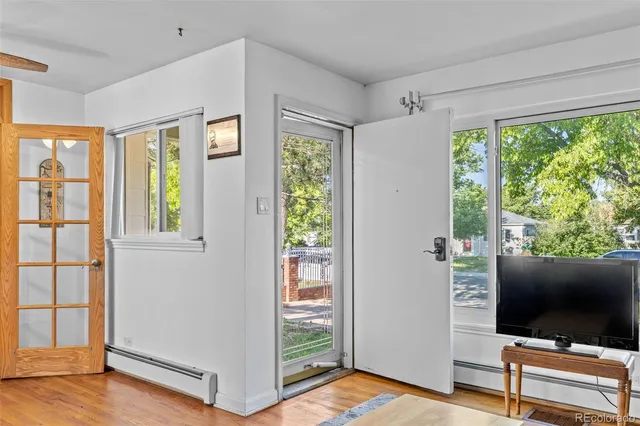 a view of a livingroom with wooden floor and a flat screen tv