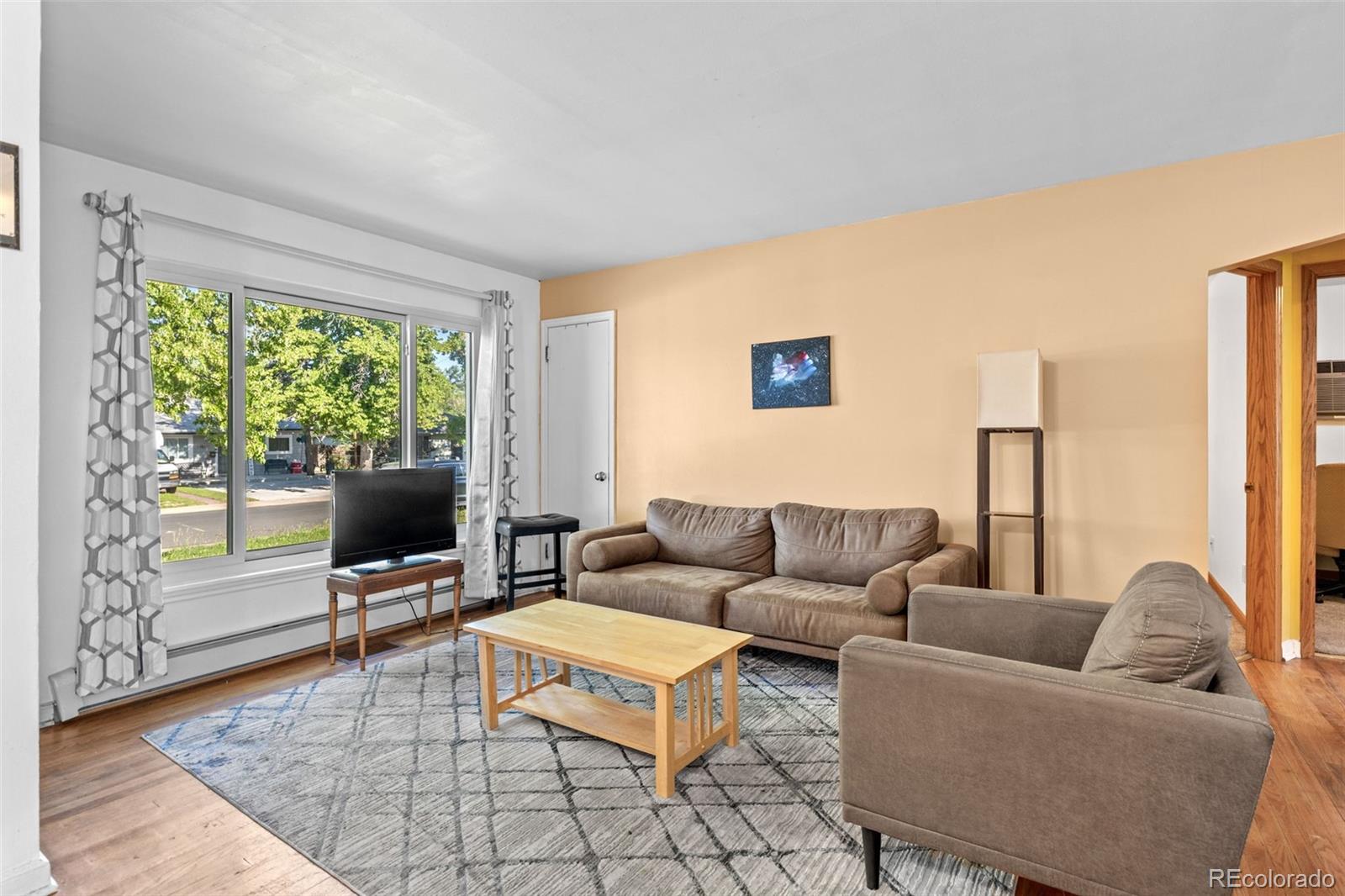 1732 Lansing Street Aurora, CO 80010 - Photo 7 of 37 a living room with furniture and a flat screen tv