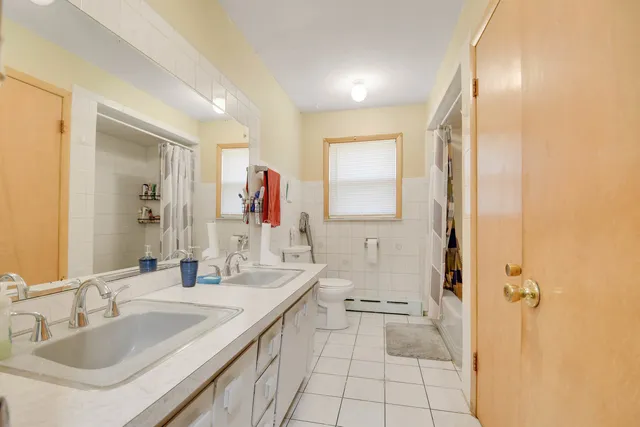 a bathroom with a tub sink and mirror