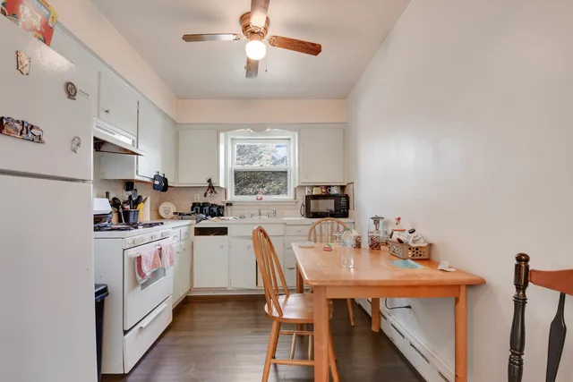 a kitchen with white cabinets stainless steel appliances and dining table