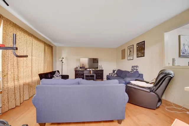 a living room with furniture large window and flat screen tv