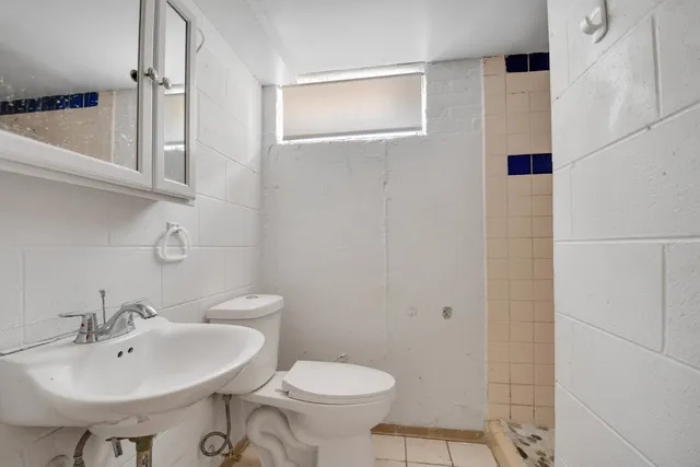 a bathroom with a sink toilet and a mirror