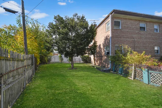 a view of a backyard with large trees and plants