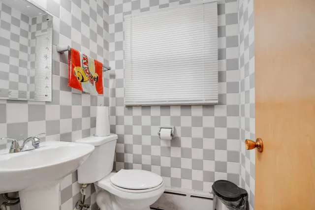 a bathroom with a toilet sink and mirror