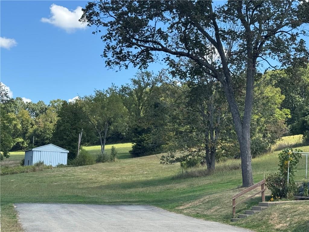 a view of a big house with a big yard and large trees
