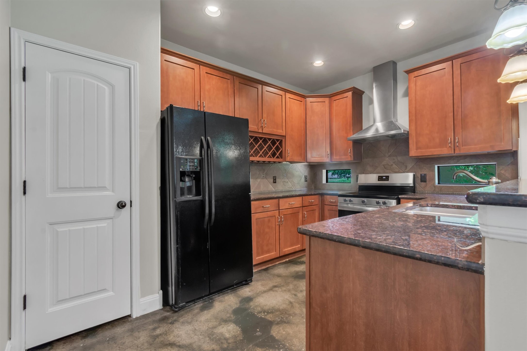 1010 Immanuel Road, Unit 103 Pflugerville, TX 78660 - Photo 12 of 30 A well-appointed kitchen features rich wood cabinetry, granite countertops, and modern appliances, creating a functional cooking space.