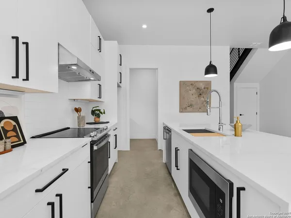 a kitchen with a stove a sink a refrigerator and cabinets