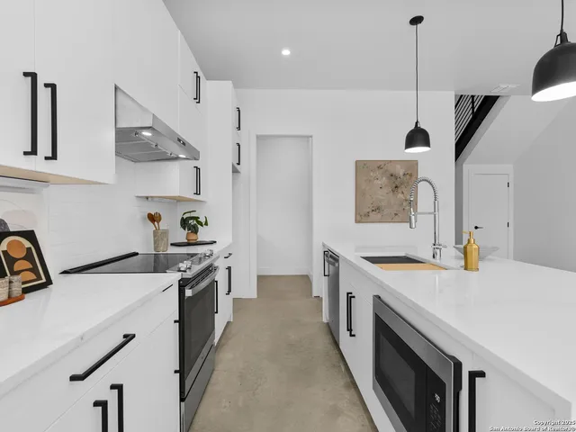 a kitchen with a stove a sink a refrigerator and cabinets