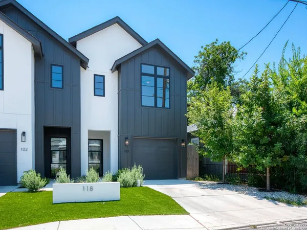 a front view of a house with a yard and trees