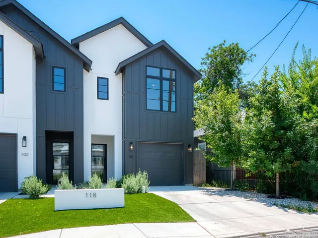 a front view of a house with a yard and trees