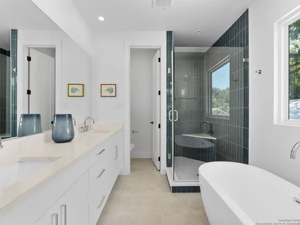 a bathroom with a tub a sink and mirror
