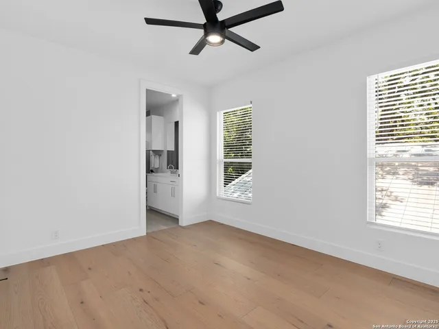 an empty room with a window and a ceiling fan