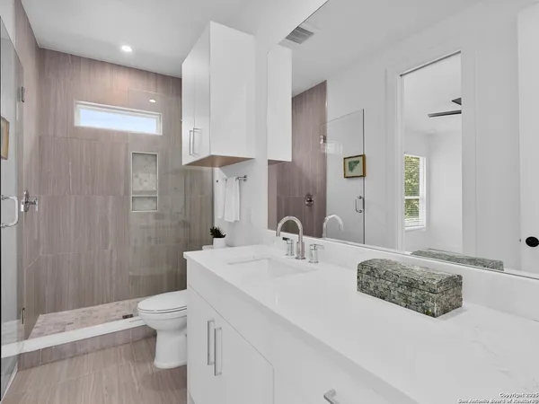 a bathroom with a sink a toilet and shower