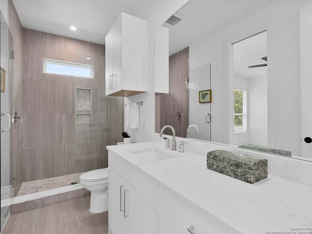 a bathroom with a sink a toilet and shower