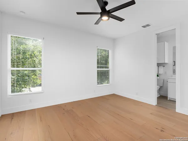 a view of empty room with wooden floor and windows