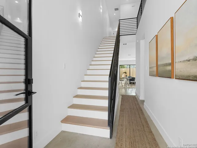 a view of staircase with lots of frames on wall and a floor to ceiling window