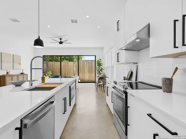 a kitchen with stainless steel appliances a sink a stove and a wooden floors