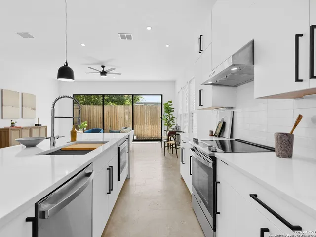 a kitchen with stainless steel appliances a sink a stove and a wooden floors