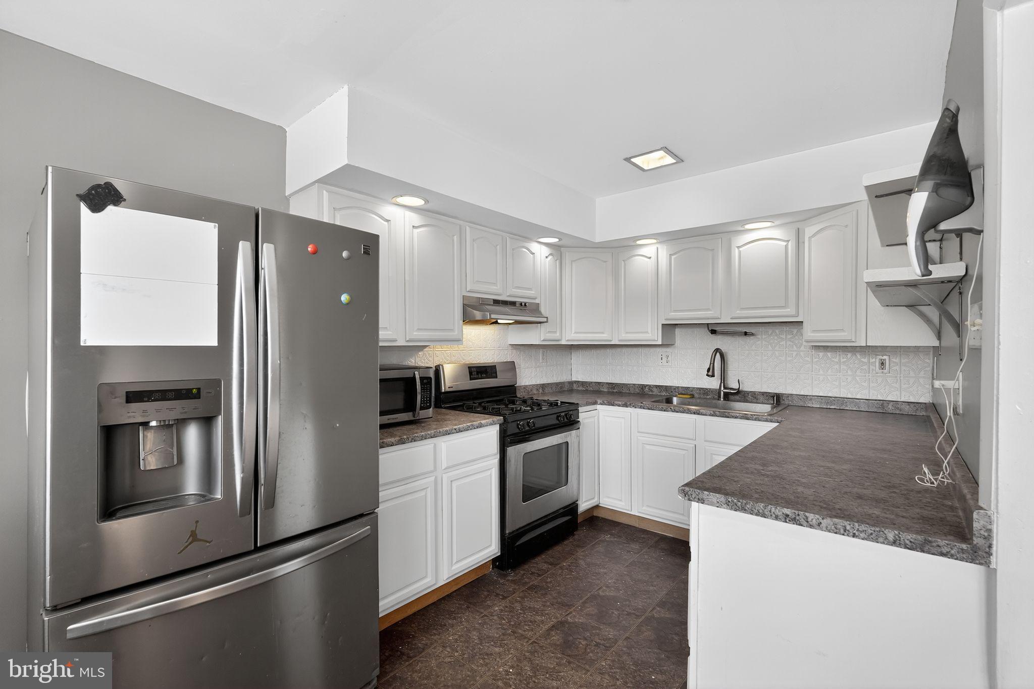 12791 Dunks Ferry Road Philadelphia, PA 19154 - Photo 7 of 26 a kitchen with a sink a refrigerator and cabinets
