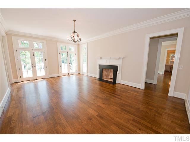 2506 Anderson Drive Raleigh, NC 27608 - Photo 4 of 12 a empty room with wooden floor fireplace and windows