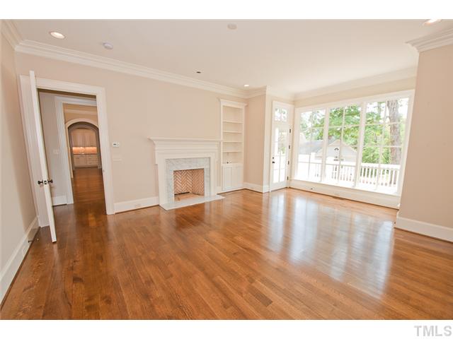 2506 Anderson Drive Raleigh, NC 27608 - Photo 7 of 12 a view of empty room with wooden floor and fireplace