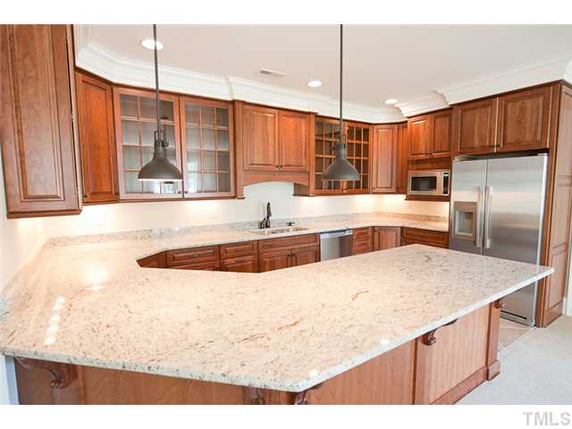 2506 Anderson Drive Raleigh, NC 27608 - Photo 10 of 12 a large kitchen with kitchen island a large counter top space appliances and cabinets
