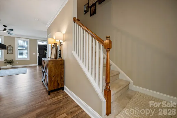 a view of a hallway with wooden floor and staircase