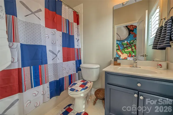 a bathroom with a toilet sink vanity tub and mirror