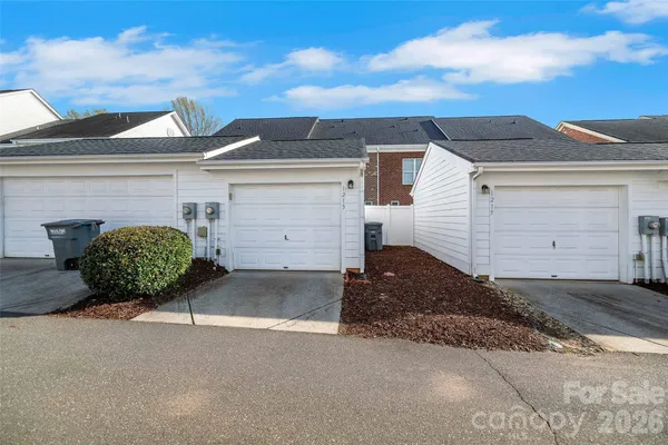 a view of a white house with a yard and garage