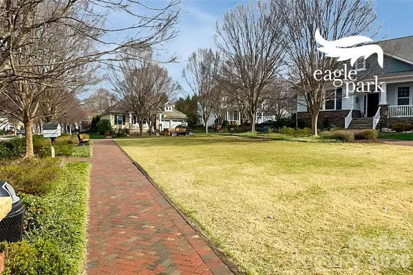 a view of swimming pool with outdoor seating and trees in the background