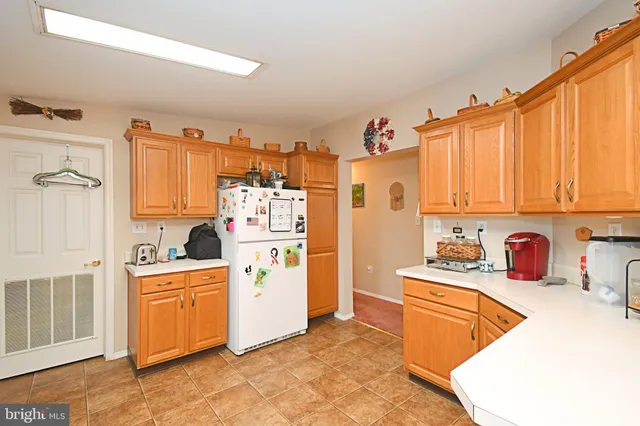 a kitchen with stainless steel appliances a refrigerator a sink and wooden cabinets