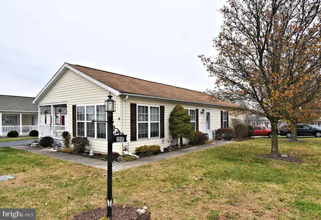 a front view of a residential houses with yard and trees