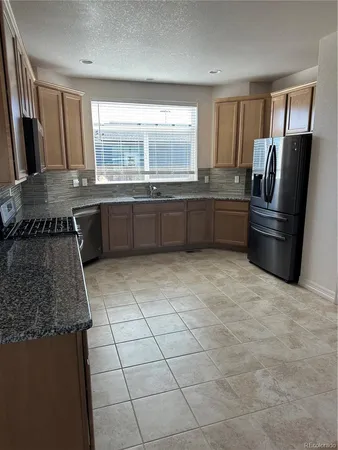 a kitchen with granite countertop sink and cabinets