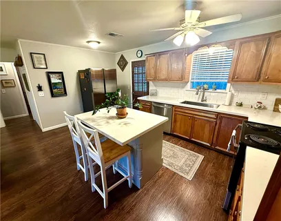 a kitchen with a table chairs sink and wooden floor
