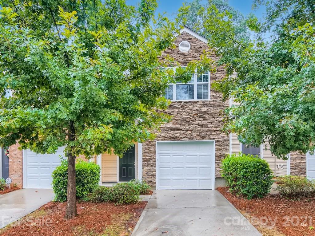 a front view of a house with a tree