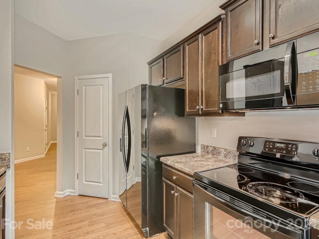 4040 Queensbridge Road Charlotte, NC 28213 - Photo 11 of 28 a kitchen with stainless steel appliances granite countertop a refrigerator and a stove top oven