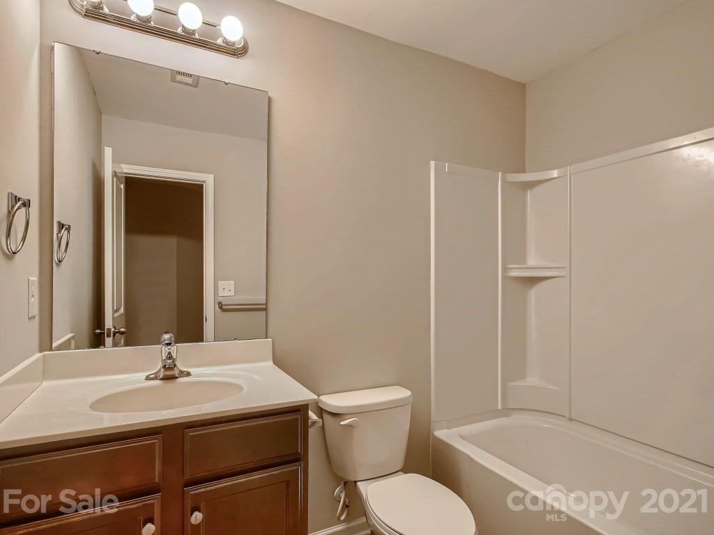 4040 Queensbridge Road Charlotte, NC 28213 - Photo 23 of 28 a bathroom with a granite countertop sink toilet a mirror and shower