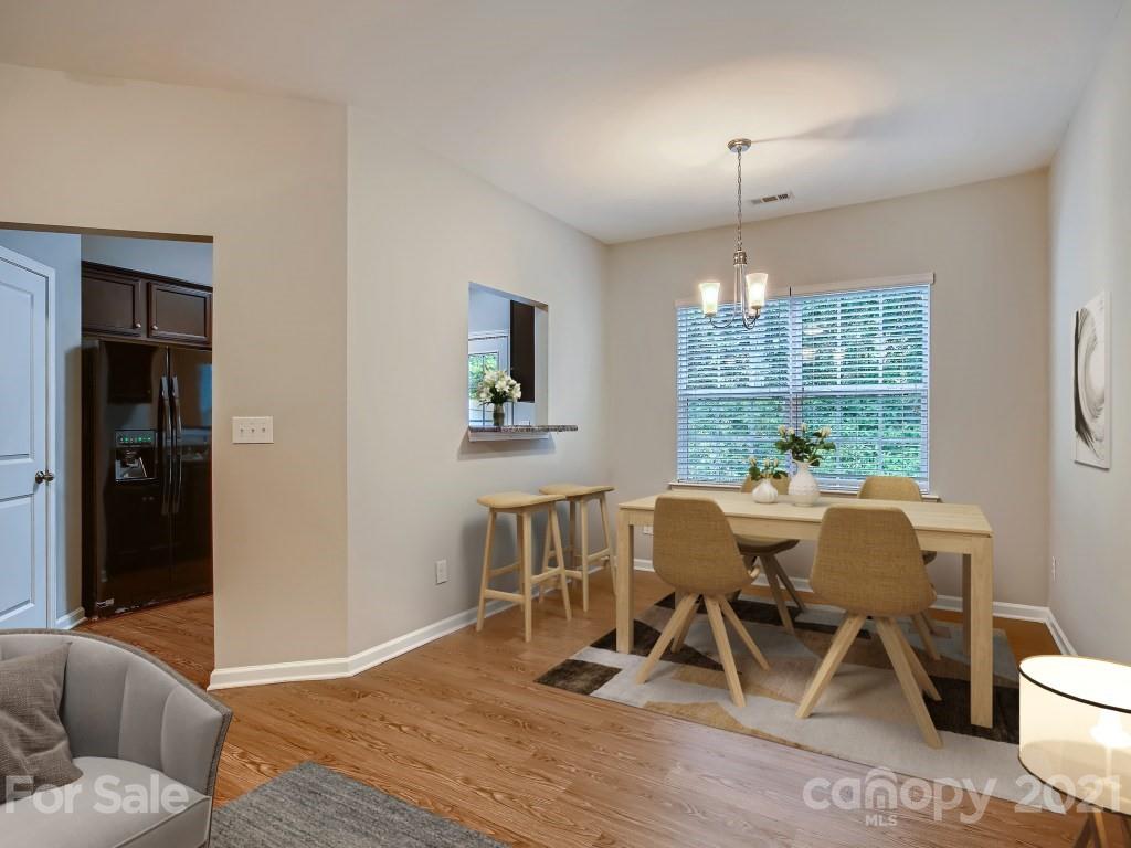 4040 Queensbridge Road Charlotte, NC 28213 - Photo 7 of 28 a dining room with furniture a chandelier and wooden floor