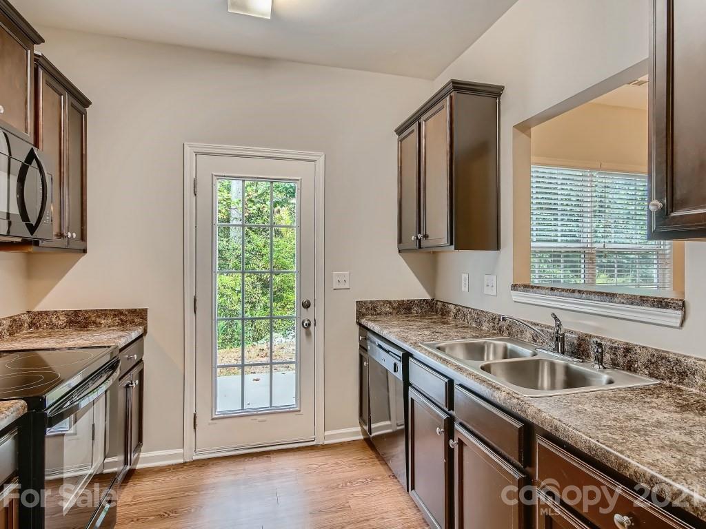 4040 Queensbridge Road Charlotte, NC 28213 - Photo 8 of 28 a kitchen that has a sink a stove and a wooden cabinets