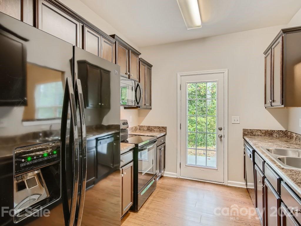 4040 Queensbridge Road Charlotte, NC 28213 - Photo 9 of 28 a kitchen with stainless steel appliances granite countertop a stove top oven a sink and a refrigerator