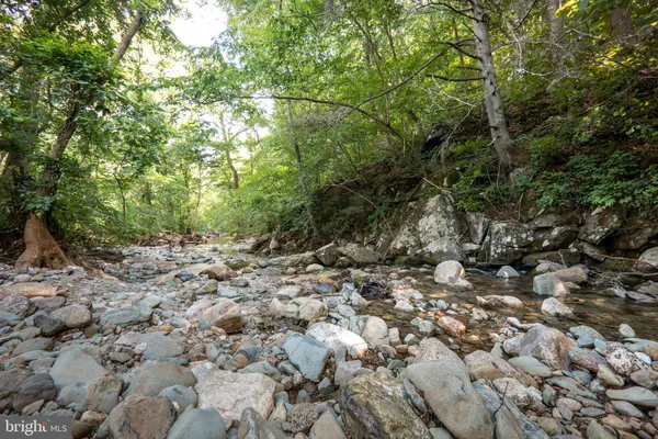 an aerial view of residential house with outdoor space and trees all around
