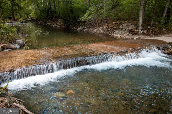 a view of a chair and fire pit in the middle of a yard